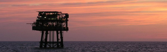 Centrica Energy UK Audrey offshore platform at sea with the sun setting in the background.